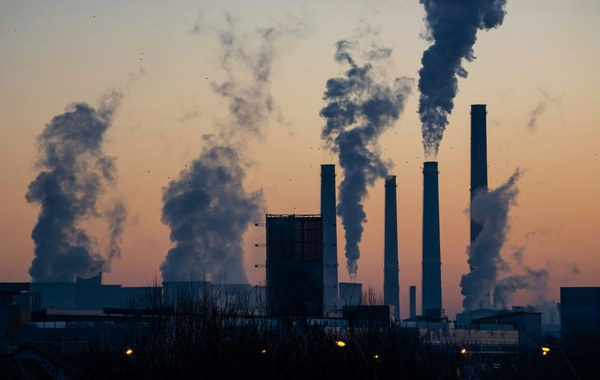 Power-plant smokestacks at dusk — carbon emissions and climate policy